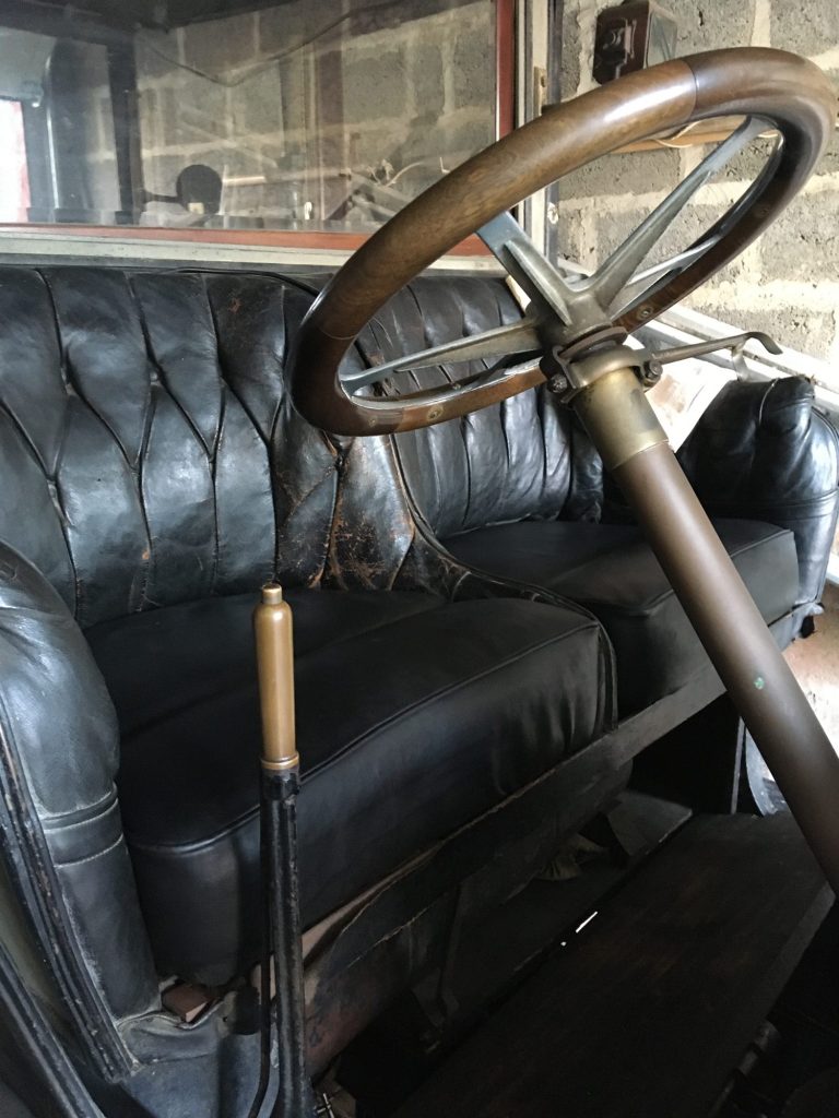 Restauration à l'ancienne avec du crin végétal et cuir noir des assises d'une Renault de 1908.